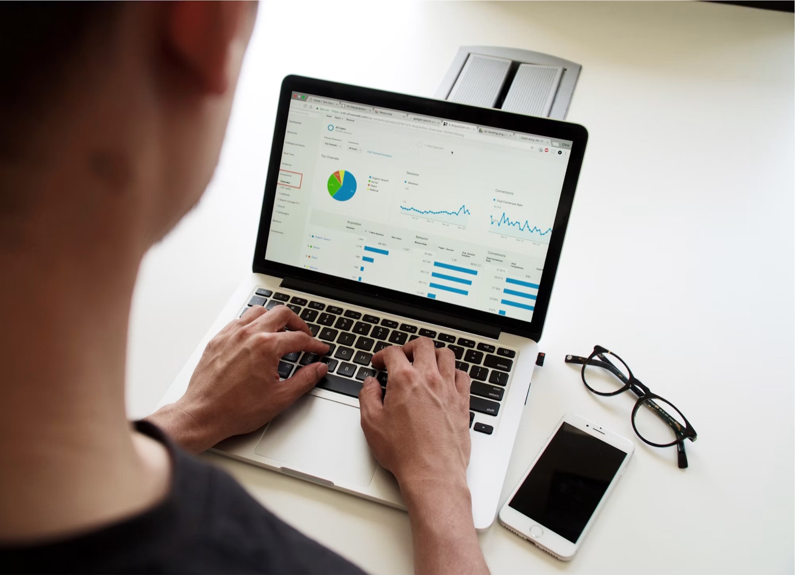 Analyst reviewing reporting dashboards on a laptop