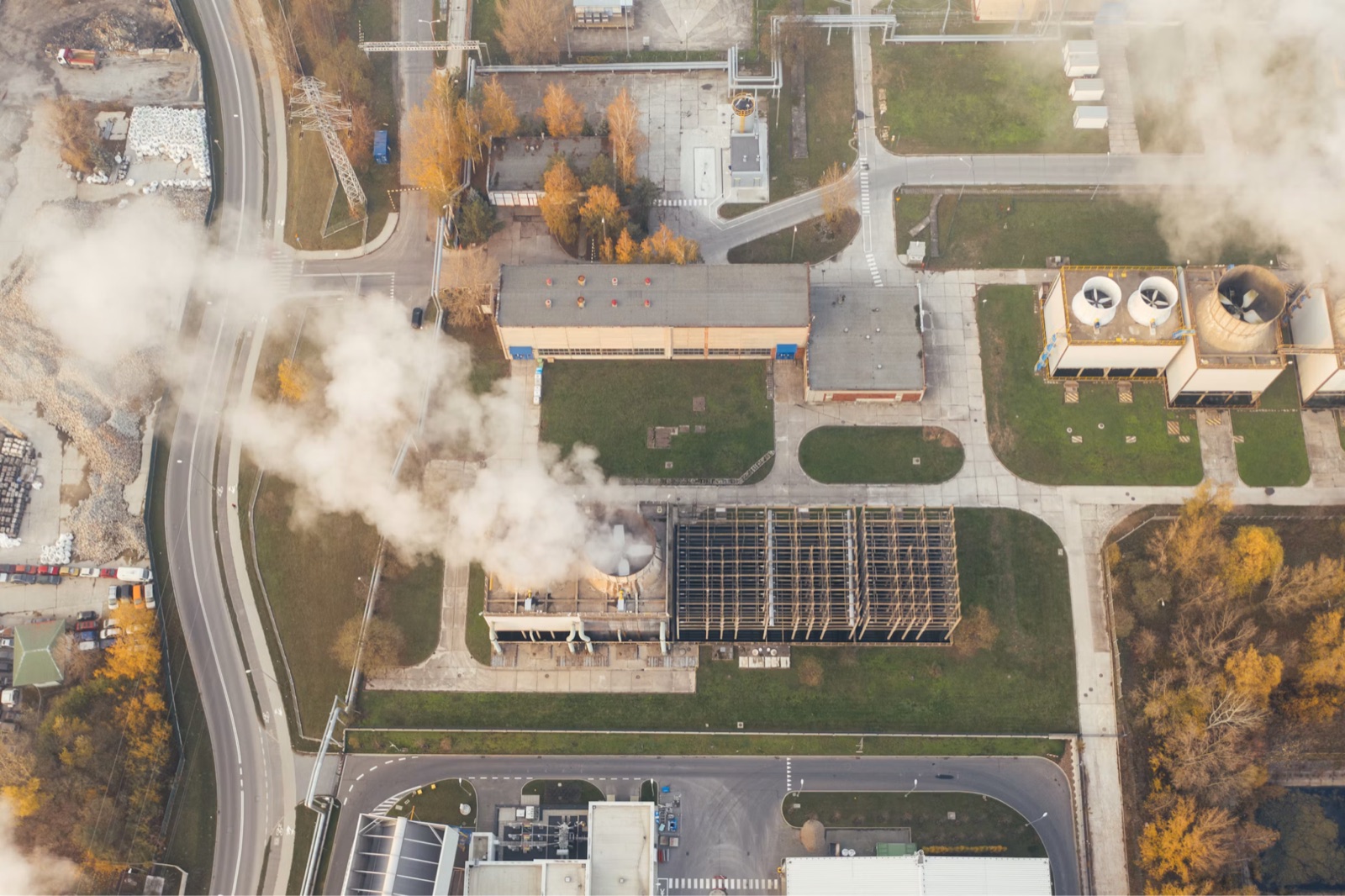 Aerial view of an industrial plant with steam rising from its cooling towers